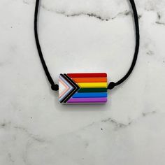 Squish Level: 5 Durability Level: 5 A silicone fidget necklace of the LGBTQ+ Progress Pride Flag. The cord has sliding knots so the length is adjustable. The longest length it can be adjusted to is about 32 inches, meaning it can hang down about 16 inches. You can run your finger over the texture, squish, bend, or chew on the pendent to fidget. The entire pendent is made of a soft, smooth, food-grade silicone.  My fidget jewelry is for adults. Clean often with soap and warm water. Discard if the Calming Crafts, Fidget Jewelry, Fidget Pen, Progress Pride Flag, Chew Necklace, Fidget Necklace, Pride Stuff, Cute Animal Quotes, Cool Fidget Toys