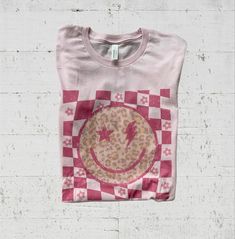 Shop The Checkered Smiley Face Tee! #smile #tshirt #graphictee #shopsmall #boutiqueshopping #boutique #fashion #fashionblogger #fashionista #springstyle #springoutfitideas Megan Outfit, Checkered Smiley Face, Smiley Graphic, Smiley Face Graphic, Smiley Face Tee, Smiley Face Tshirt, Pink Checkered, Face Graphic, Cute Graphic Tees