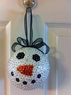 a snowman ornament hanging on the front door with black and white polka dots