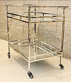 a metal and glass serving cart on wheels