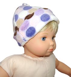 a doll wearing a white shirt and blue polka dot hat on it's head