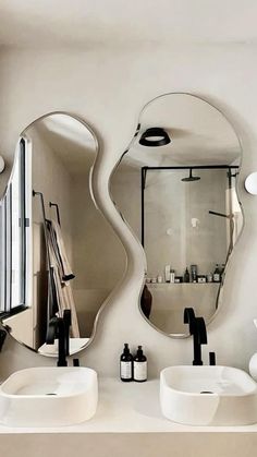 a bathroom with two sinks and mirrors on the wall