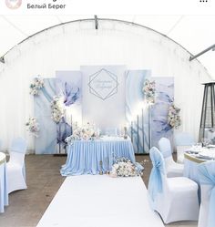 a wedding setup with blue and white decor on the walls, tables and chairs set up for an event