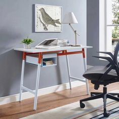 a desk with a laptop on it and a lamp next to it in a room