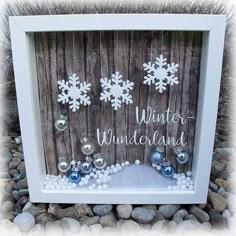 a white frame with snowflakes and ornaments in front of a wooden background that says winter wonderland