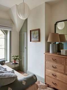 a bedroom with a bed, dresser and mirror on the wall in front of it