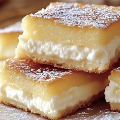 four pieces of dessert sitting on top of a white paper towel covered in powdered sugar