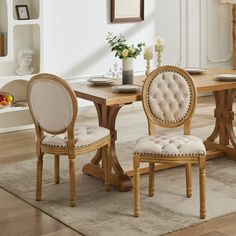 a dining room table with chairs and a rug on the floor in front of it