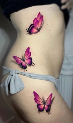 two pink butterflies on the side of a woman's stomach, one is purple