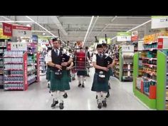 two men in kilts walking through a store aisle