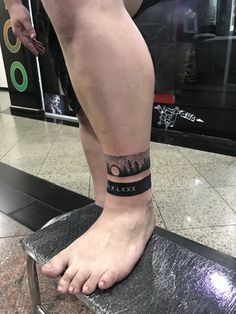 a person with a tattoo on their foot sitting on a stool in an airport lobby