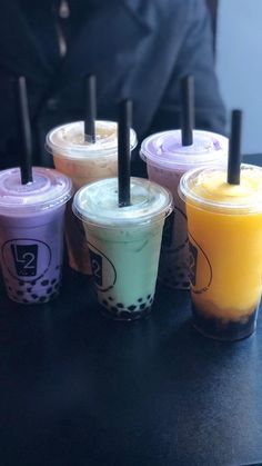 four different colored drinks sitting on top of a table