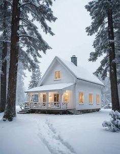 a white house in the snow surrounded by trees