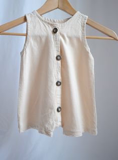 Unisex beige linen romper with sizes for babies up to 6T. Perfect for wearing on hot summer days. Loose fit unisex romper featuring wood buttons. Pattern by TinyDesignCo: https://www.etsy.com/shop/tinydesignpattern?ref=yr_purchases Cream Bubble Romper For Beach In Summer, Cream Bubble Romper For Beach And Summer, Beige Cotton Bubble Romper For Summer, Casual Cream Bubble Romper For Summer, Summer Beige Cotton Bubble Romper, Sleeveless Beige Bubble Romper For Spring, Beige Sleeveless Bubble Romper For Spring, Cute Cotton Bubble Romper With Buttons, Cotton Bubble Romper With Buttons For Spring