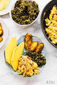 two plates filled with different types of food on top of a white marble countertop