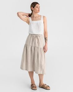 "This tiered linen skirt UBUD in natural melange boasts an elasticated waist and drawstring, allowing for a tailored fit. It showcases a fashionable waist tunnel and an extra pleat line at the hips for added style. Side pockets are included for convenience. Details: * A-line fit * Midi-length * Adjustable waist strap * Tiered at the hips * Features side pockets * Elasticated waist with a drawstring for additional waist width adjustment * The model is wearing size S and is 5'11\" (180 cm) tall. M Beige Linen Gathered Skirt, Relaxed Linen Tiered Maxi Skirt, Beige Linen Tiered Skirt, Flowy Linen Tiered Skirt, Linen Tiered Skirt, Wrinkled Clothes, Tiered Midi Skirt, Linen Bottoms, Skirt Knee Length