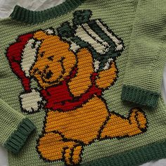 a knitted sweater with the image of winnie the pooh holding a wrench