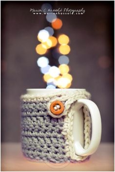 a crocheted coffee cup with a button on it