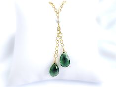 This lariat necklace features two lovely green quartz briolette gemstones. The color of the quartz is a deep green - very rich and vivid! The green contrasts nicely with the bright gold of the chain. In the center of the necklace is a white Swarovski pearl. MATERIALGold filled chainSwarovski crystal pearlGenuine green quartz briolette stonesSIZE15x10mm green quartz stones16-inch chain (excluding lengths of drops)5mm Swarovski pearlCLOSURELobster claspWHAT IS GOLD FILLED?We used to have just 2 choices: pure gold or gold plated. The first was very expensive, and the second was…well…not very good.Our gold filled jewelry is designed to last you a lifetime without the price of solid gold pieces.Instead of a thin layer of gold that can be easily scratched, gold filled jewelry is made with multip Green Lariat Jewelry For Formal Occasions, Formal Green Lariat Jewelry, Elegant Green Lariat Necklace, Elegant Green Dangle Drop Necklace, Green Dangle Lariat Necklace As Gift, Green Dangle Lariat Necklace For Gift, Green Lariat Necklace For Gift, Elegant Green Lariat Necklace As Gift, Green Drop Necklace With Adjustable Chain As Gift