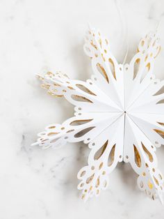 a paper snowflake sitting on top of a marble countertop next to a string