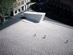 three people are standing on the roof of a building