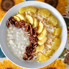 a white bowl filled with oatmeal topped with sliced bananas and pecans