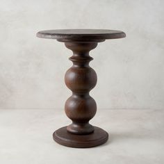 a wooden table with three balls on it's top and one ball at the base