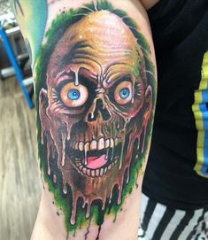 a person with a tattoo on their arm that is covered in green and red paint