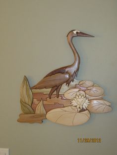 a bird is standing on top of some water lilies and leaves in front of a gray wall