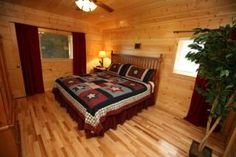 a bed in a room with wooden floors and walls