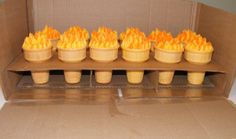 a cardboard box filled with cupcakes on top of a counter