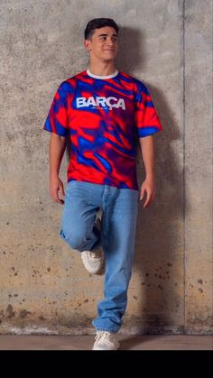 a man standing in front of a wall wearing a shirt with the word barca on it