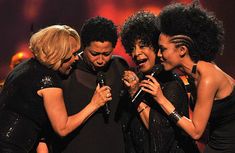 the group of women are laughing together on stage