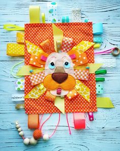 an animal made out of fabric on top of a wooden table next to scissors and thread