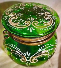 a green and gold decorated box sitting on top of a table