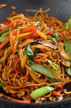 a wok filled with noodles and vegetables