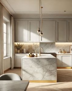 a kitchen with marble counter tops and white cabinets, along with an island in the middle