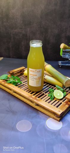 a bottle of juice sitting on top of a wooden tray