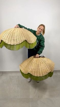 a woman holding two large wicker umbrellas