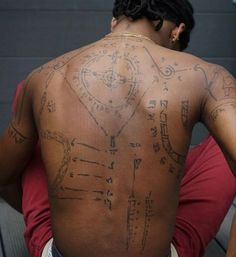 the back of a man with tattoos on his body