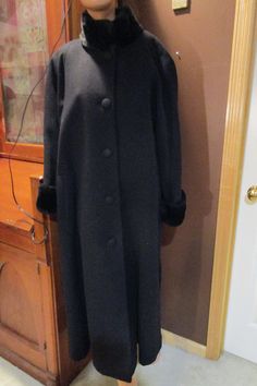 "Vintage, Albert Nipon Boutique black coat, faux fur at neck and wrists. 60s look.  Size 10, made in USA.  Elegant black 100% wool.  Acetate lining.  Large covered buttons down the front.  Excellent condition, no flaws or damage.  Small shoulder pads.  The white circles are from camera flashes, they are not on the coat. Measurements: shoulders across front:  20\" pit to pit across front:  24\" waist across front:  25\" hips across front:  27\" length:  51\" sleeve inseam:  19\" Please read all measurements and view all photos provided before purchasing as I do NOT accept returns. I do my best to list accurate measurements and notate all visible flaws/signs of wear. I am happy to send additional pictures of any listing.  I am not responsible for lost or damaged packages during shipping. Ins Fashion Thoughts, 60s Look, Camera Flashes, Coat Black, Faux Fur Coat, Covered Buttons, Black Coat, Shoulder Pads, Beautiful Dresses