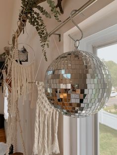 a mirror ball hanging from the ceiling next to a window