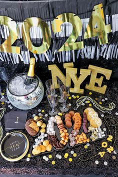 a new year's eve party with champagne, cookies and candies on the ground