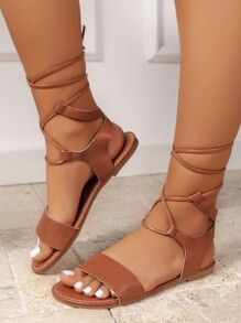 Casual Open Toe Lace-up Sandals For Beach, Casual Flat Lace-up Sandals For Beach Season, Casual Lace-up Sandals, Casual Brown Lace-up Sandals For Summer, Summer Sandals With Crisscross Strappy Design, Casual Lace-up Sandals For Beach Season, Casual Strappy Cross-tied Sandals, Summer Beach Lace-up Sandals, Trendy Brown Lace-up Sandals For Summer