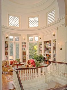 a living room filled with lots of furniture and bookshelves next to a window