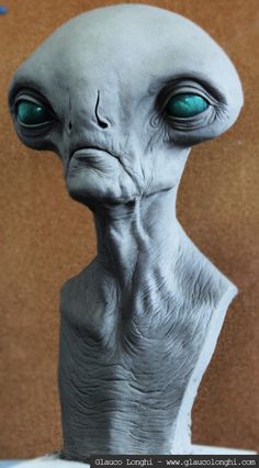 an alien head with green eyes is shown