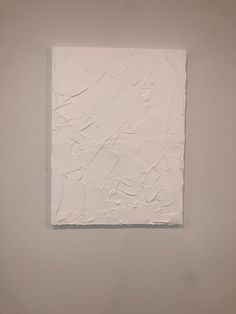 an abstract white painting hanging on the wall