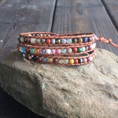 "This multi color gemstone wrap bracelet is so versatile. It is made with multi-gemstones woven on top quality natural red brown leather cord. It is accented throughout with glass beads for a little sparkle. This bracelet measures21\" to the first button closure. There are closures at 22\" and 23\". Custom sizes are available. Just send me a convo. If you like this bracelet you might also be interested in these. https://www.etsy.com/listing/263967656/leather-wrap-bracelet-beaded-wrap https://www Spiritual Multicolor Adjustable Wrap Bracelet, Multicolor Wrap Bracelet With Round Beads And Natural Stones, Multicolor Beaded Spiritual Leather Bracelet, Multicolor Gemstone Beads Wrap Bracelet As Gift, Adjustable Hand Wrapped Multicolor Leather Bracelet, Multicolor Gemstone Beads Wrap Bracelet For Healing, Spiritual Brown Braided Bracelets With Natural Stones, Multicolor Wire Wrapped Wrap Bracelet With Round Beads, Multicolor Hand Wrapped Leather Bracelet As Gift