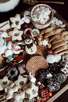 a platter filled with cookies, marshmallows and other holiday treats