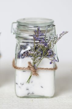 a glass jar filled with lavender flowers on top of a table